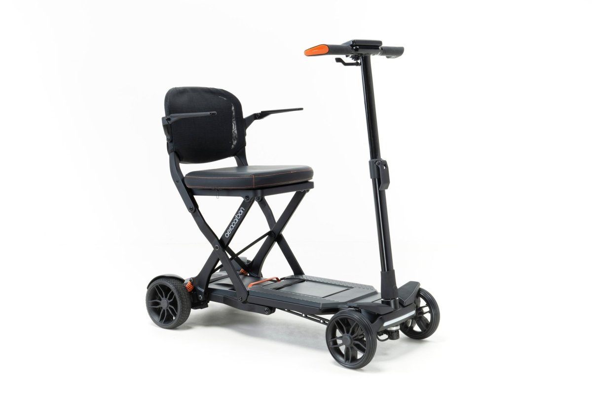 Drive DeVilbiss AeroCarbon folding travel scooter in matte black with orange accents, shown from the front three-quarter.